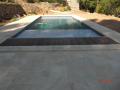 Une piscine traditionnelle en béton de couleur gris foncé dans le var à sollies pont
